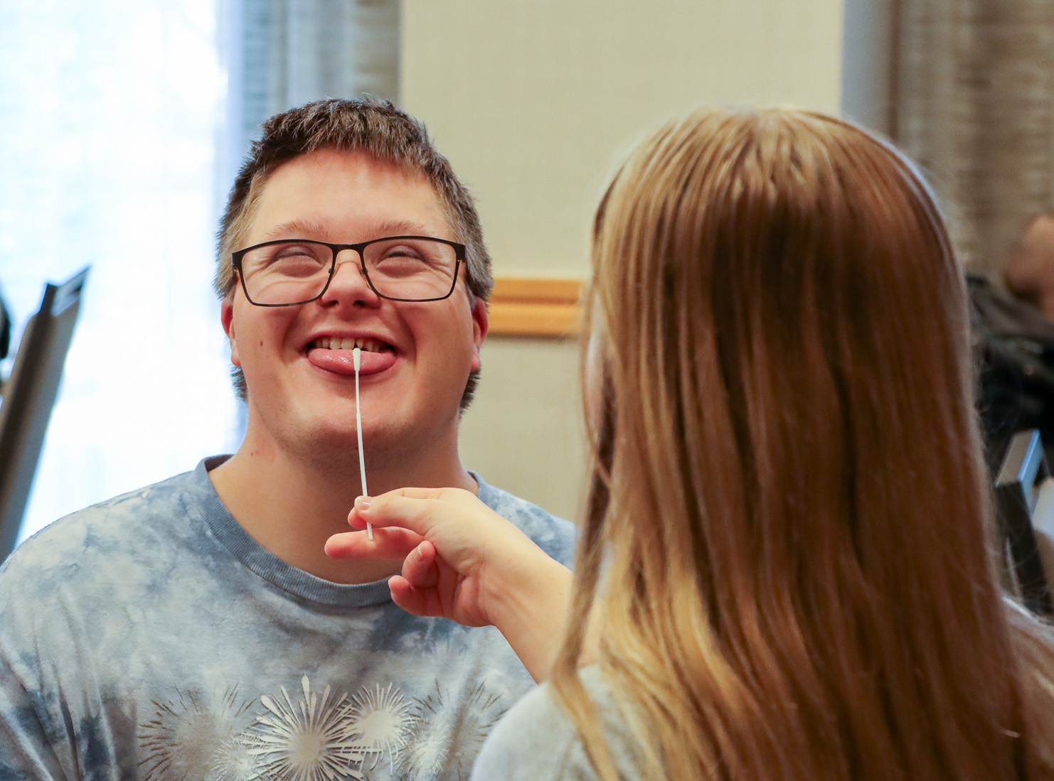 Man with Down syndrome getting his tongue swabbed for a saliva sample