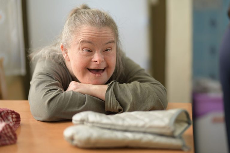 Older woman with Down syndrome sitting at a table