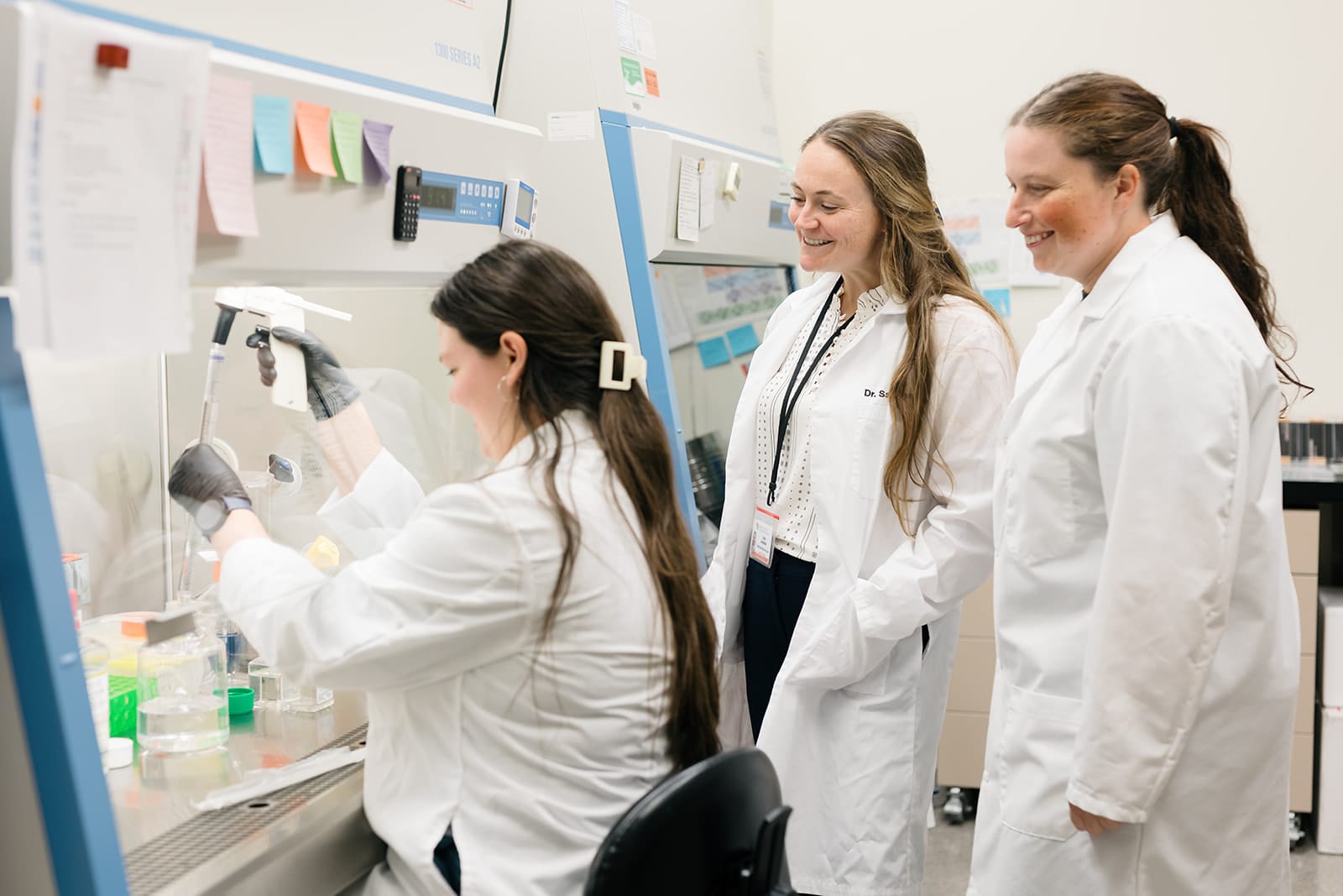 Three scientists smiling looking at specimens