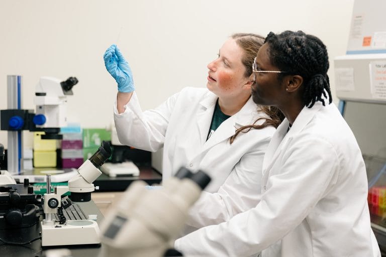 Two scientists looking at a Down syndrome biospecimen on a slide