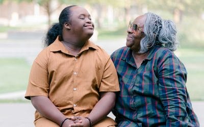 Man with Down syndrome and his mother smiling and looking at each other
